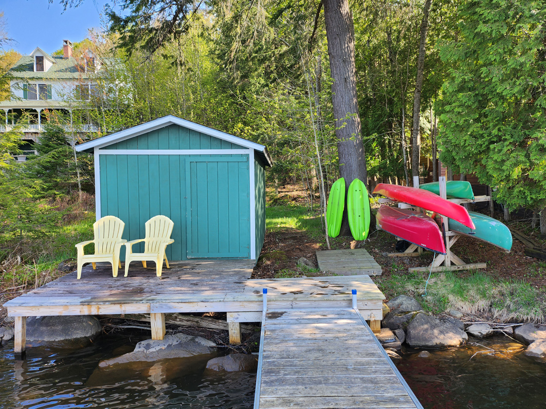 dock, adirondack chairs, kayaks and boat house